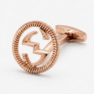 Close up view of rose gold cufflinks showing round monogram design and textured border