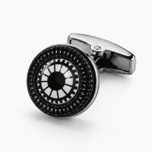 : Close-up of silver and black round cufflinks with gear wheel and sunburst engraved pattern